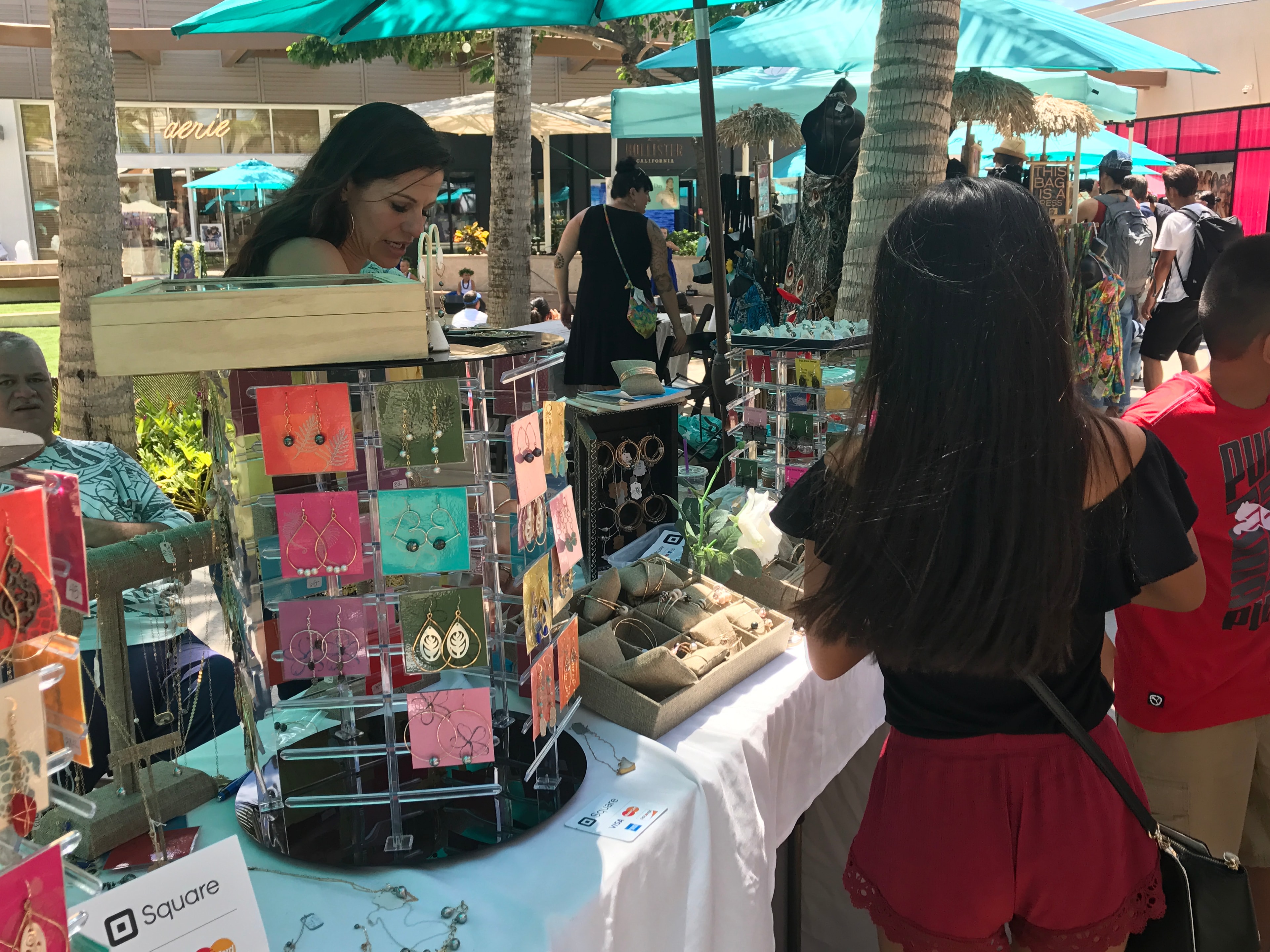 Outdoor market vendor selling handmade jewelry and accessories