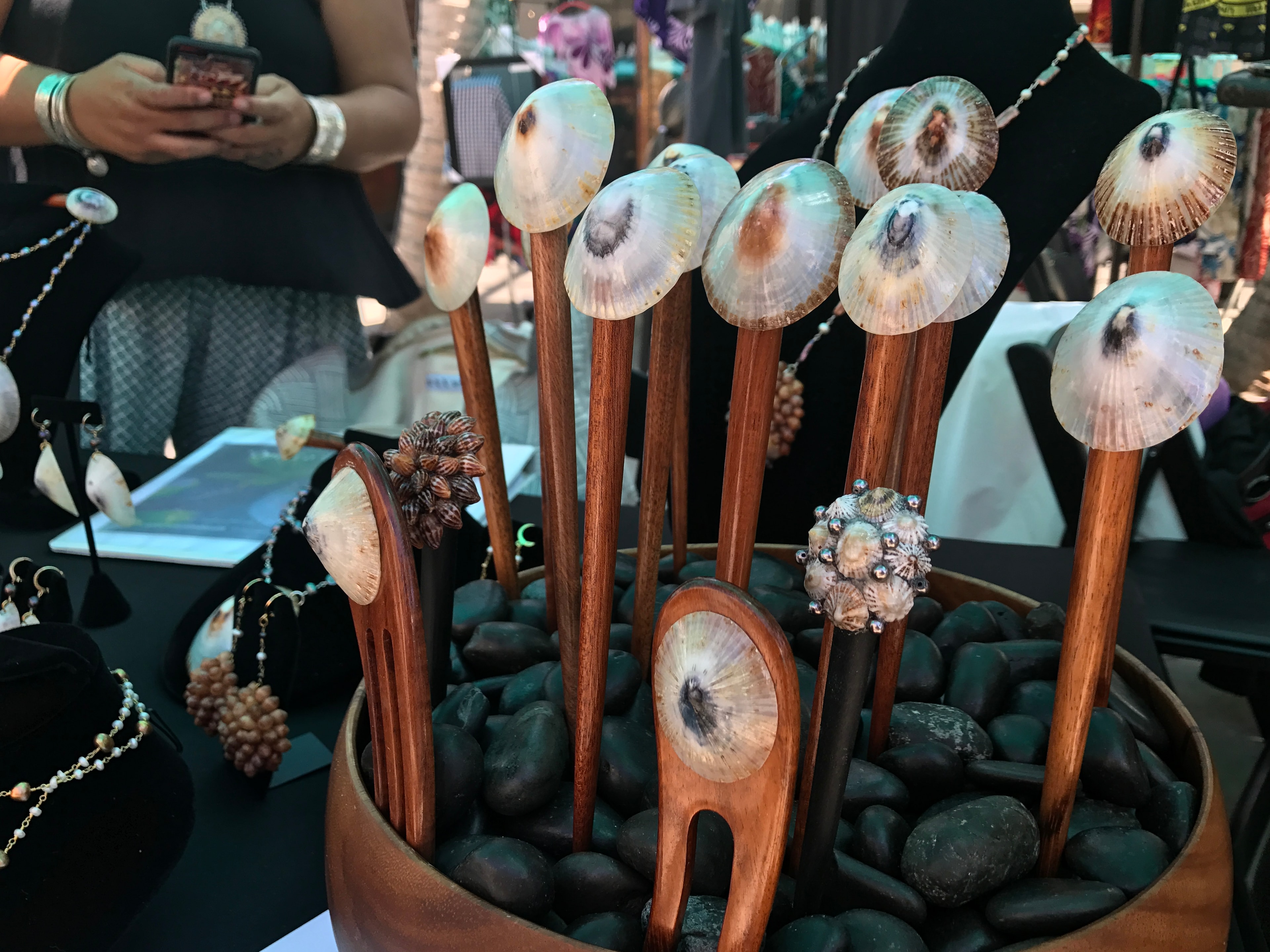 Handcrafted wooden hair sticks with shell tops displayed in bowl