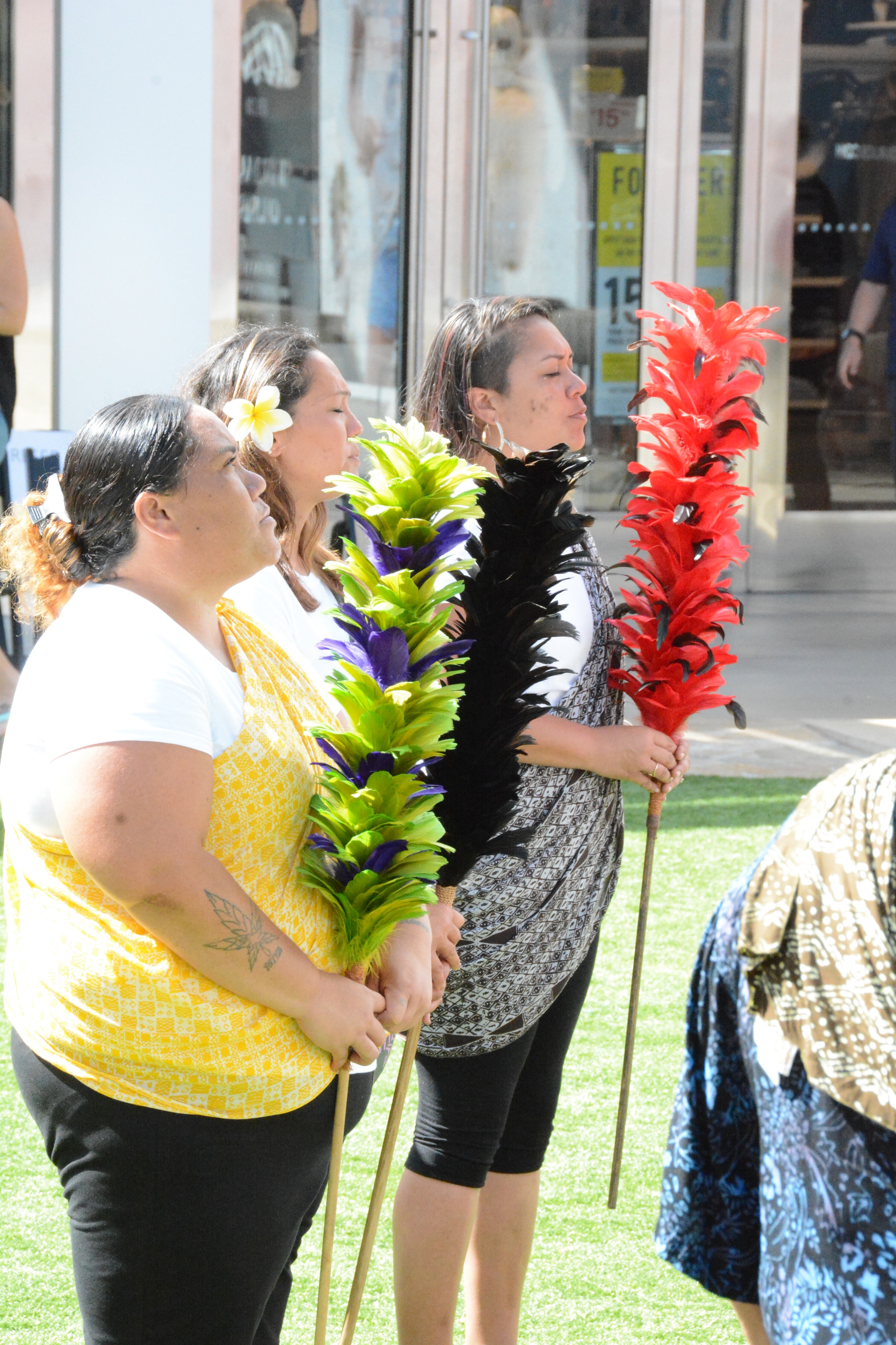 Women holding colorful tropical flowers outdoors