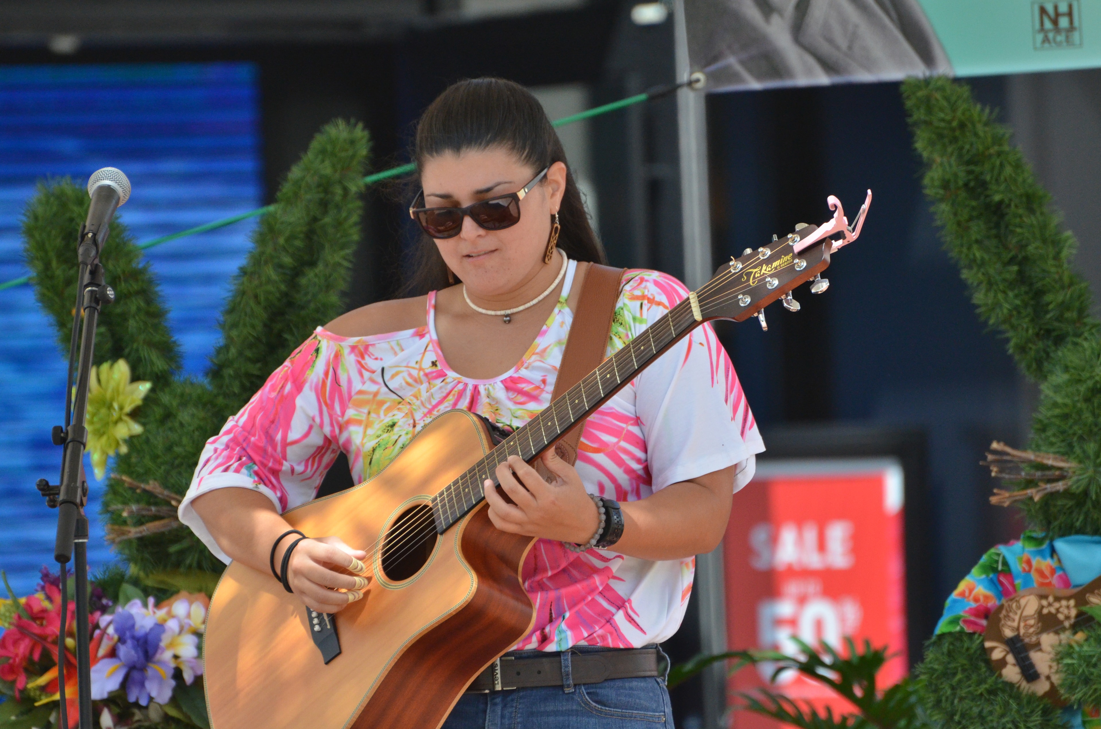 Woman performing acoustic guitar outdoor stage