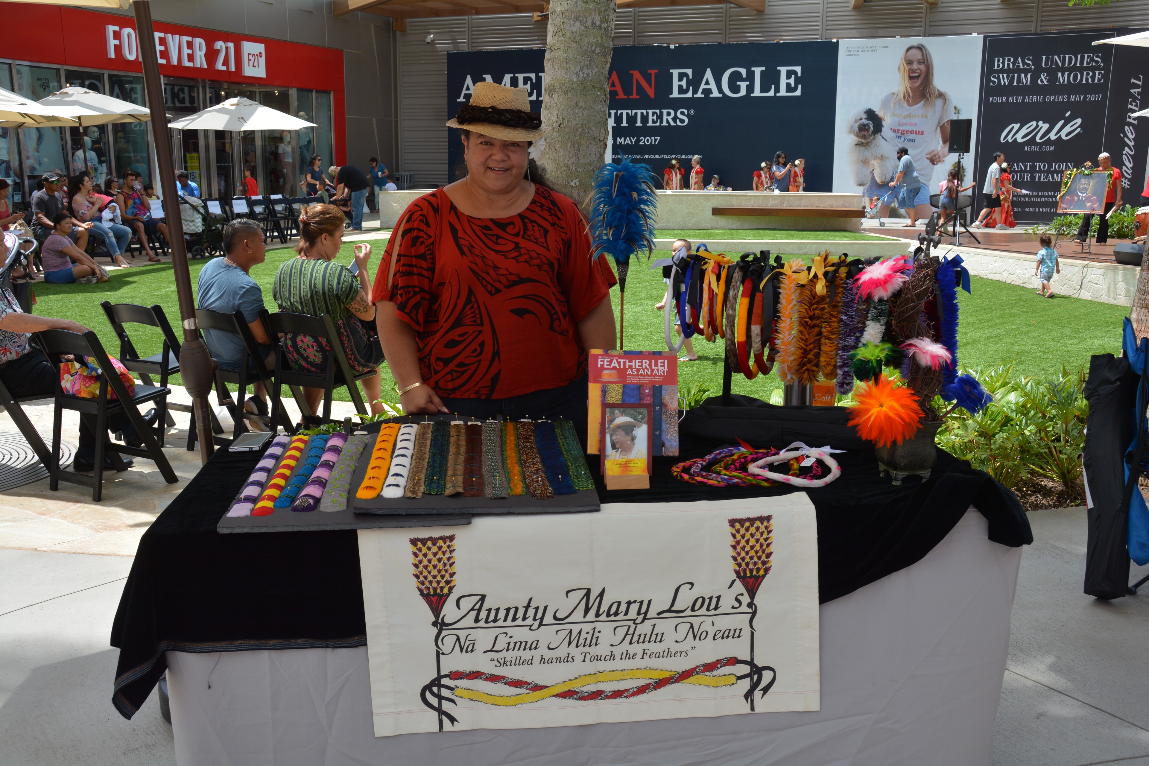 Vendor selling colorful feather lei crafts