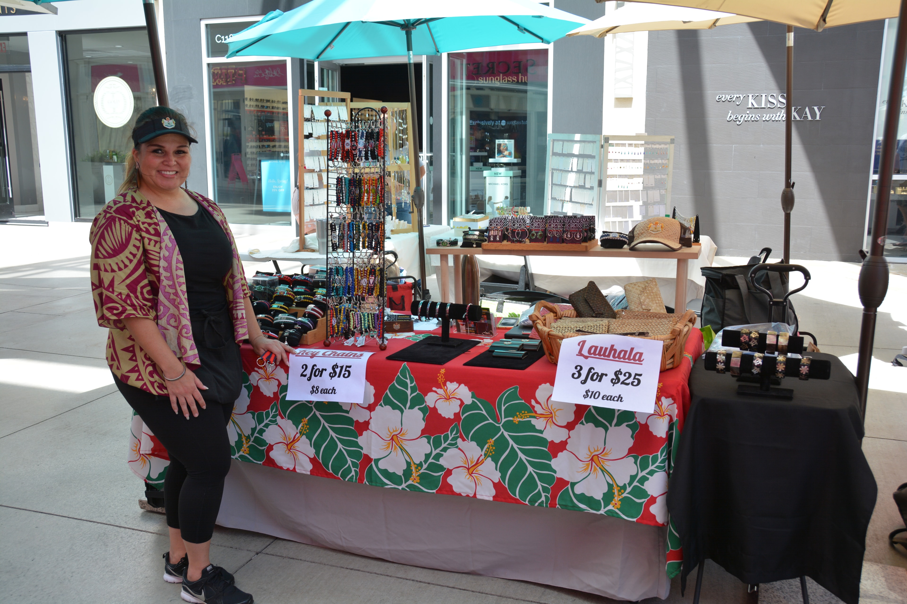 Vendor selling lauhala and key chains at outdoor market booth