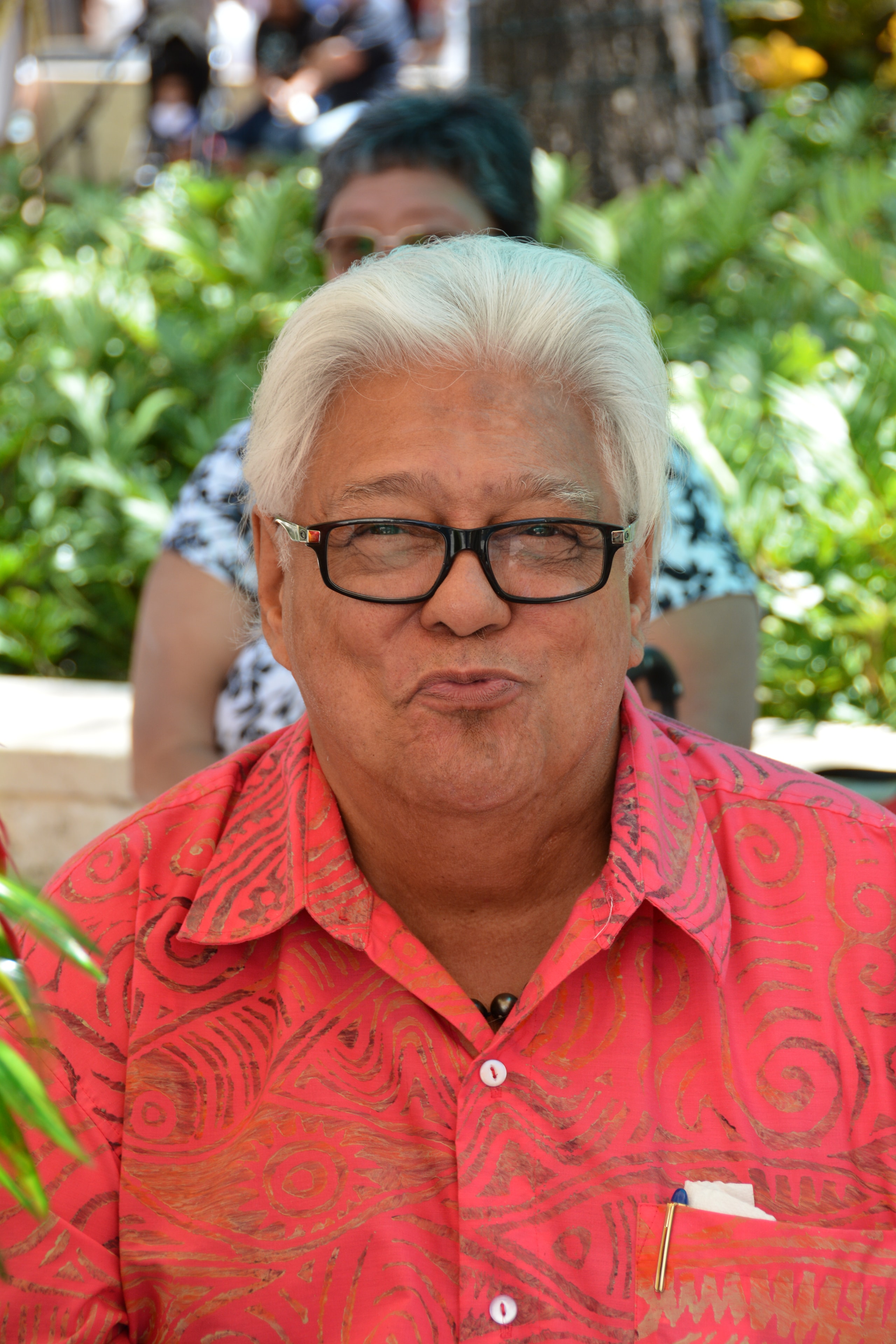 Close-up portrait of man in red patterned Hawaiian shirt at Prince Kūhiō Day event