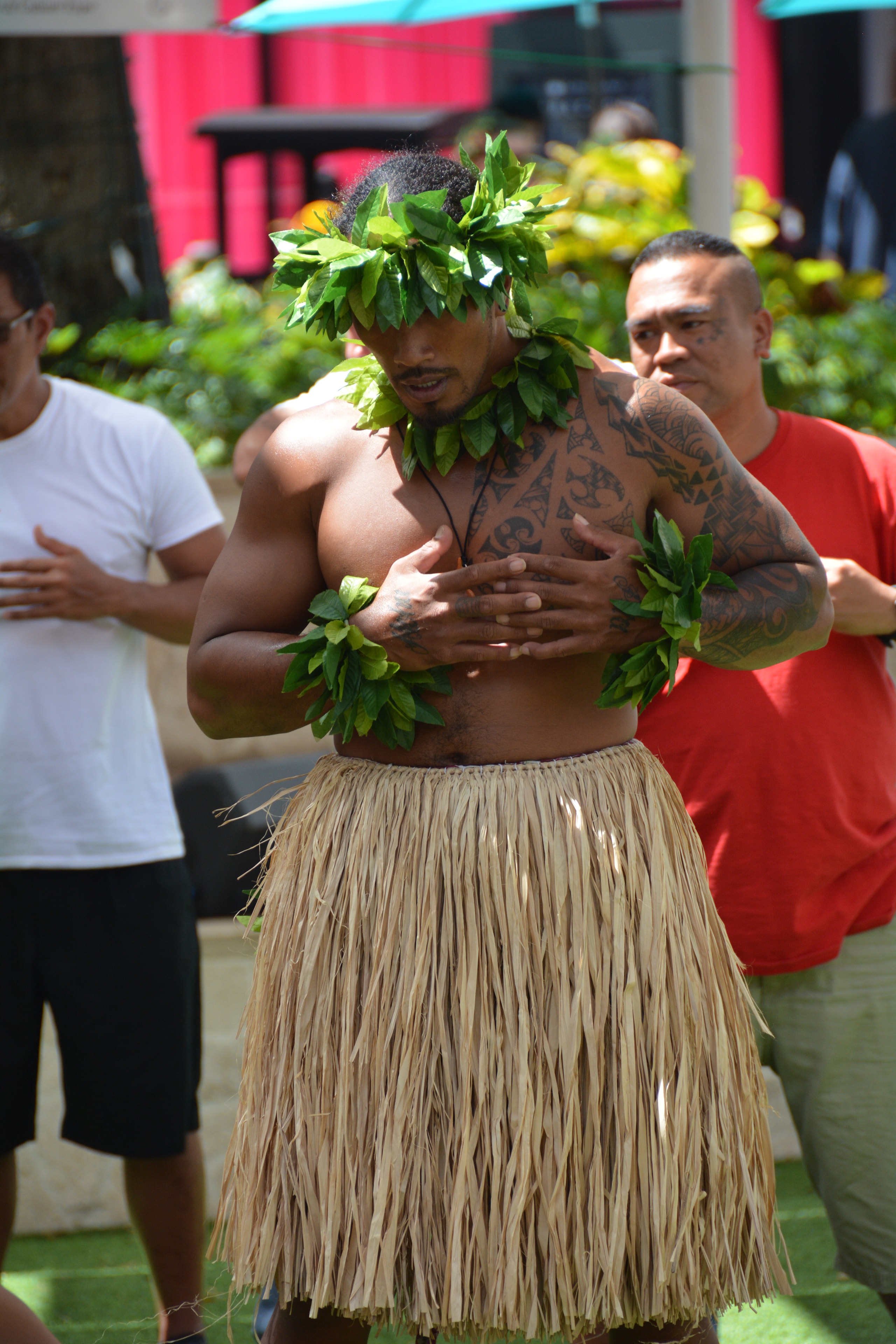 Hawaiian male dancer with traditional tattoos performing hula