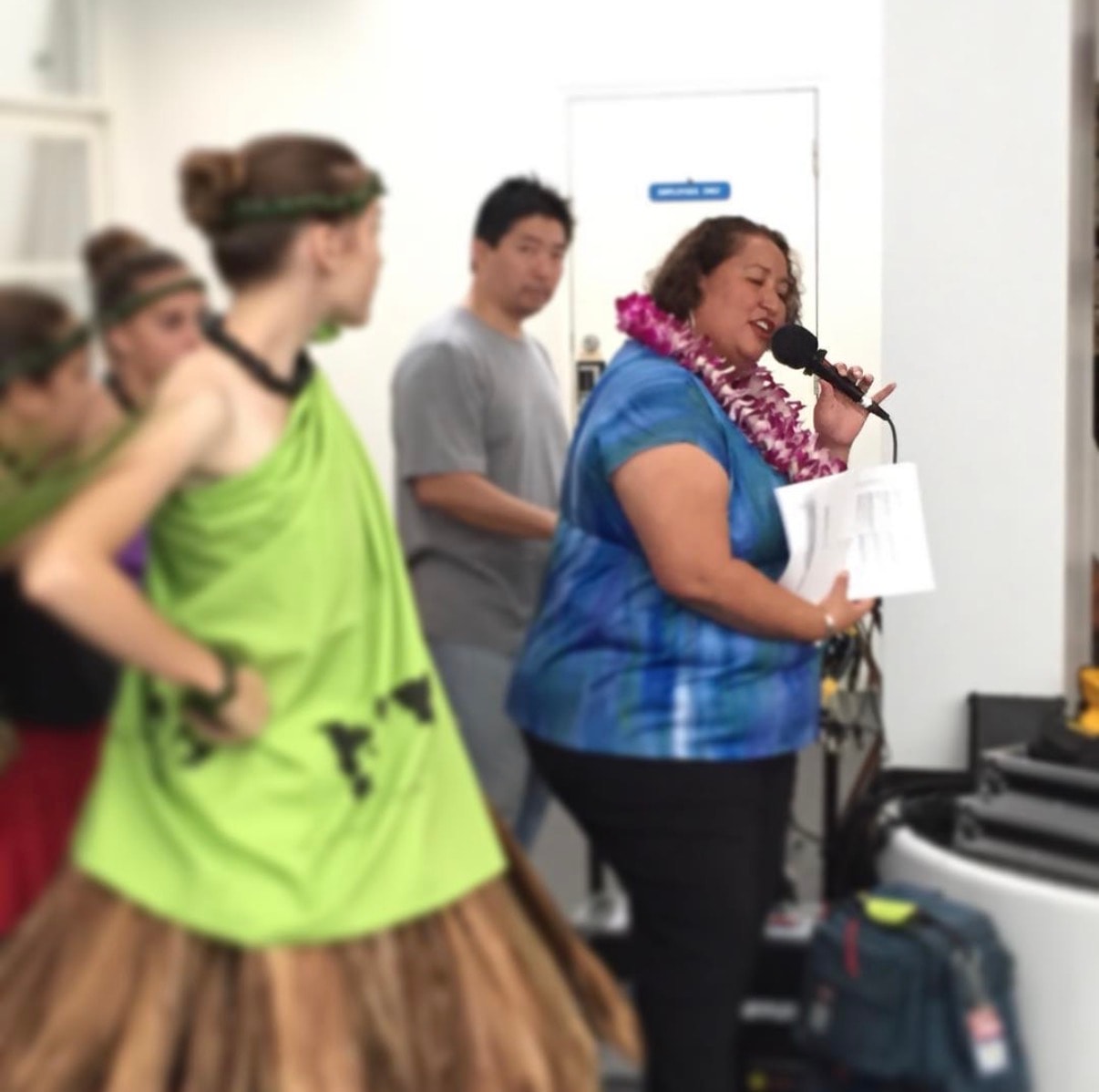 Woman speaking microphone to group indoors