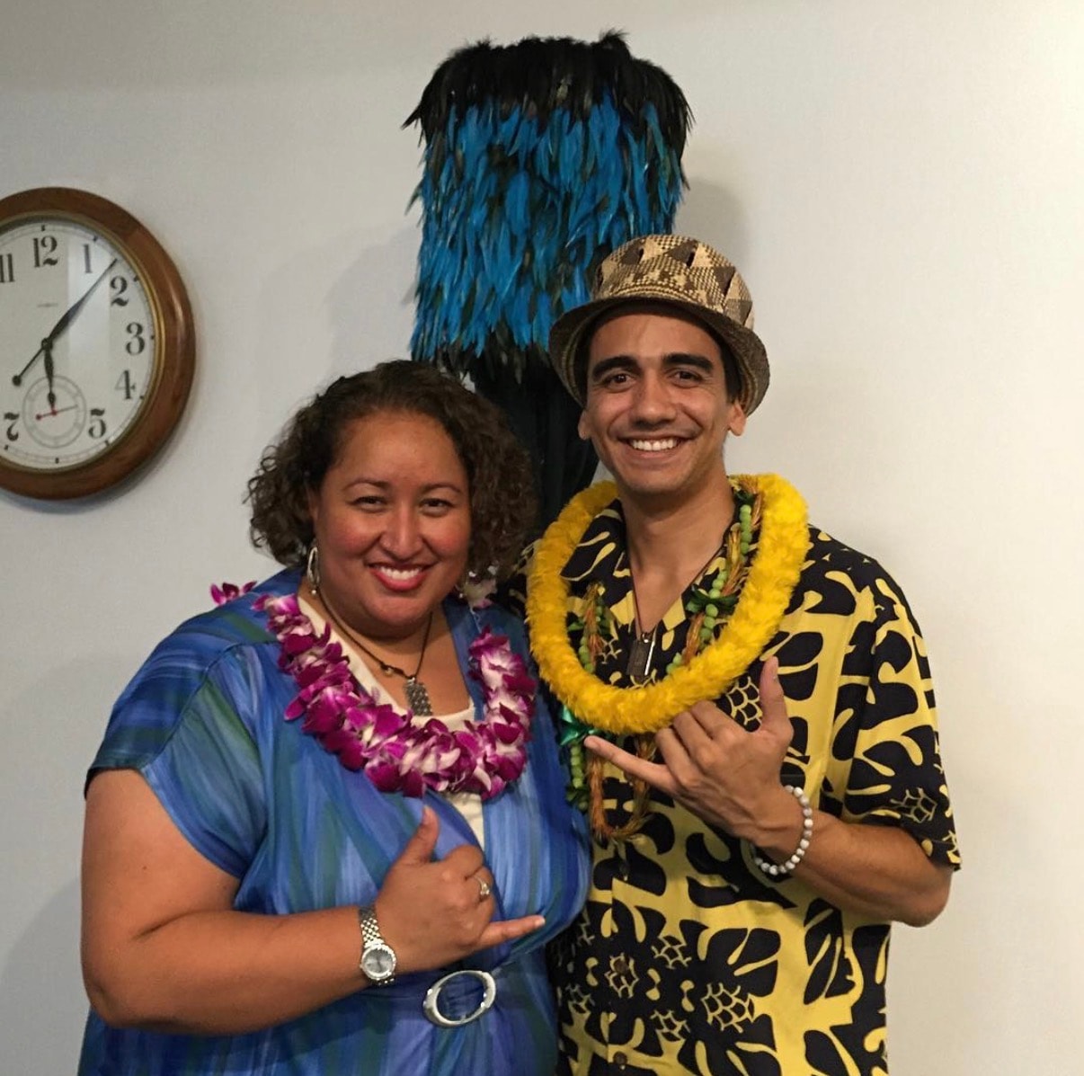 Two people wearing tropical lei and costumes smiling
