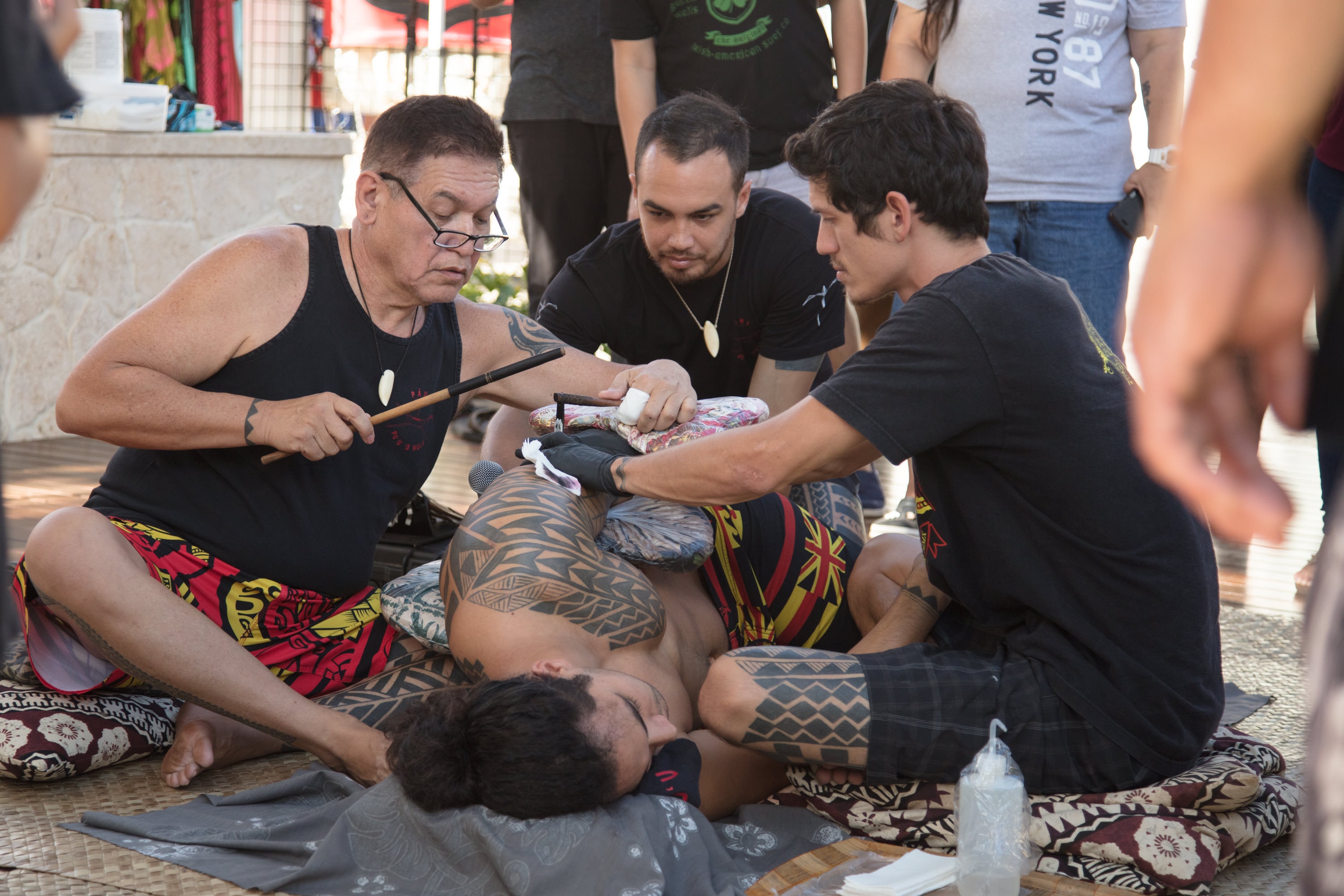 Traditional tattoo artist applying tribal design