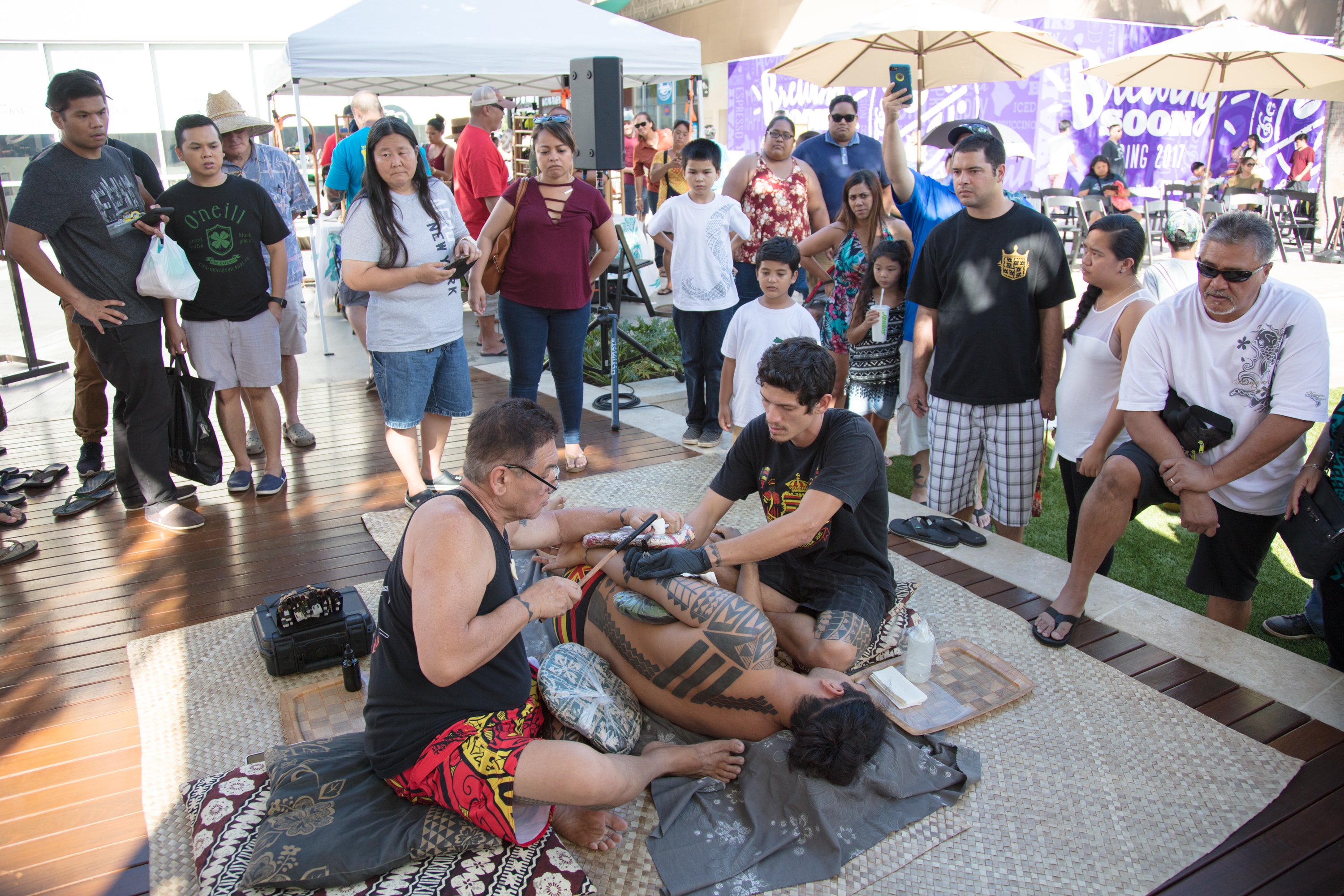 Tattoo artist demonstrating traditional tattooing
