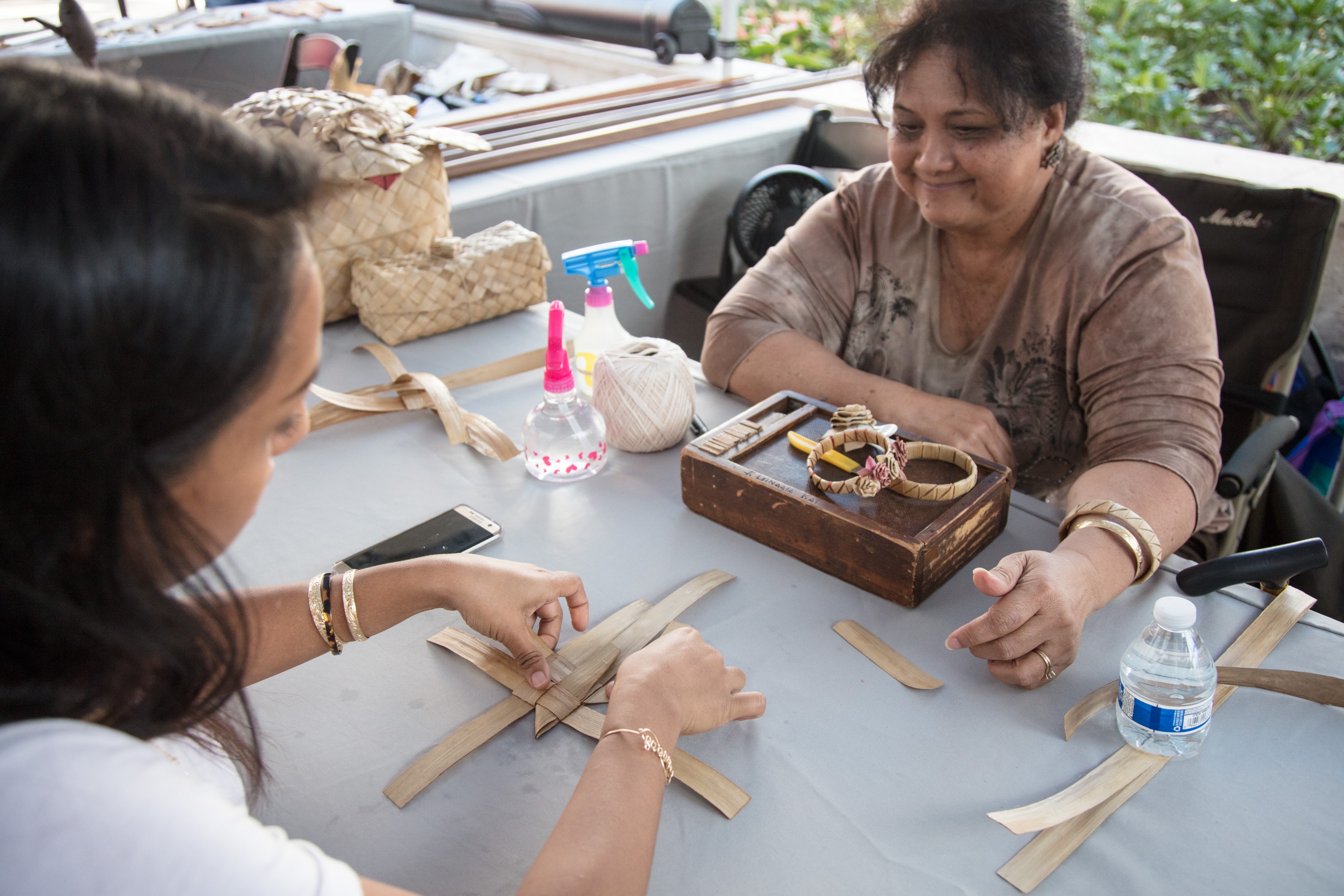 Women weaving baskets outdoor workshop