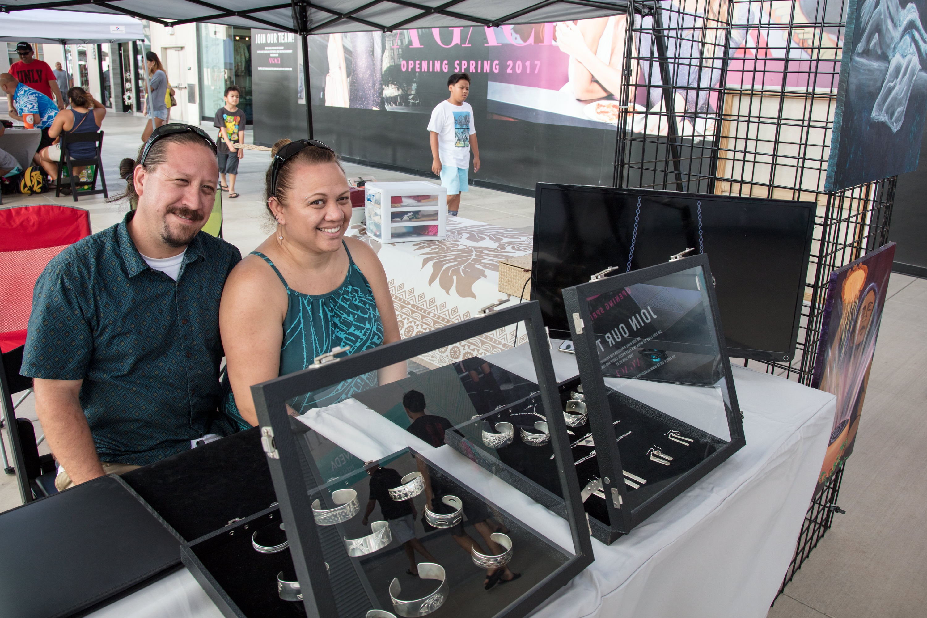 Couple browsing jewelry at outdoor market booth