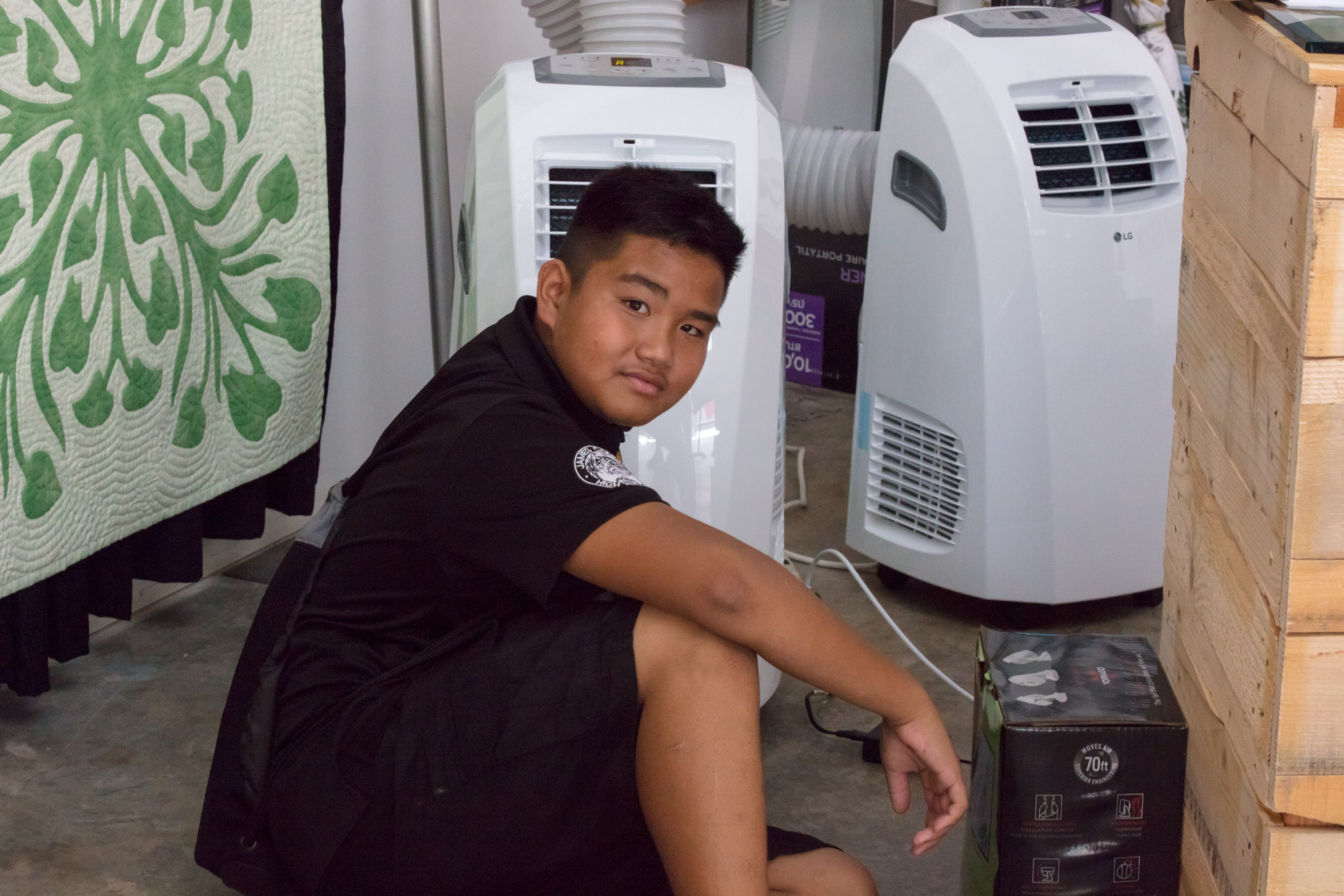 Boy posing with portable air conditioning units