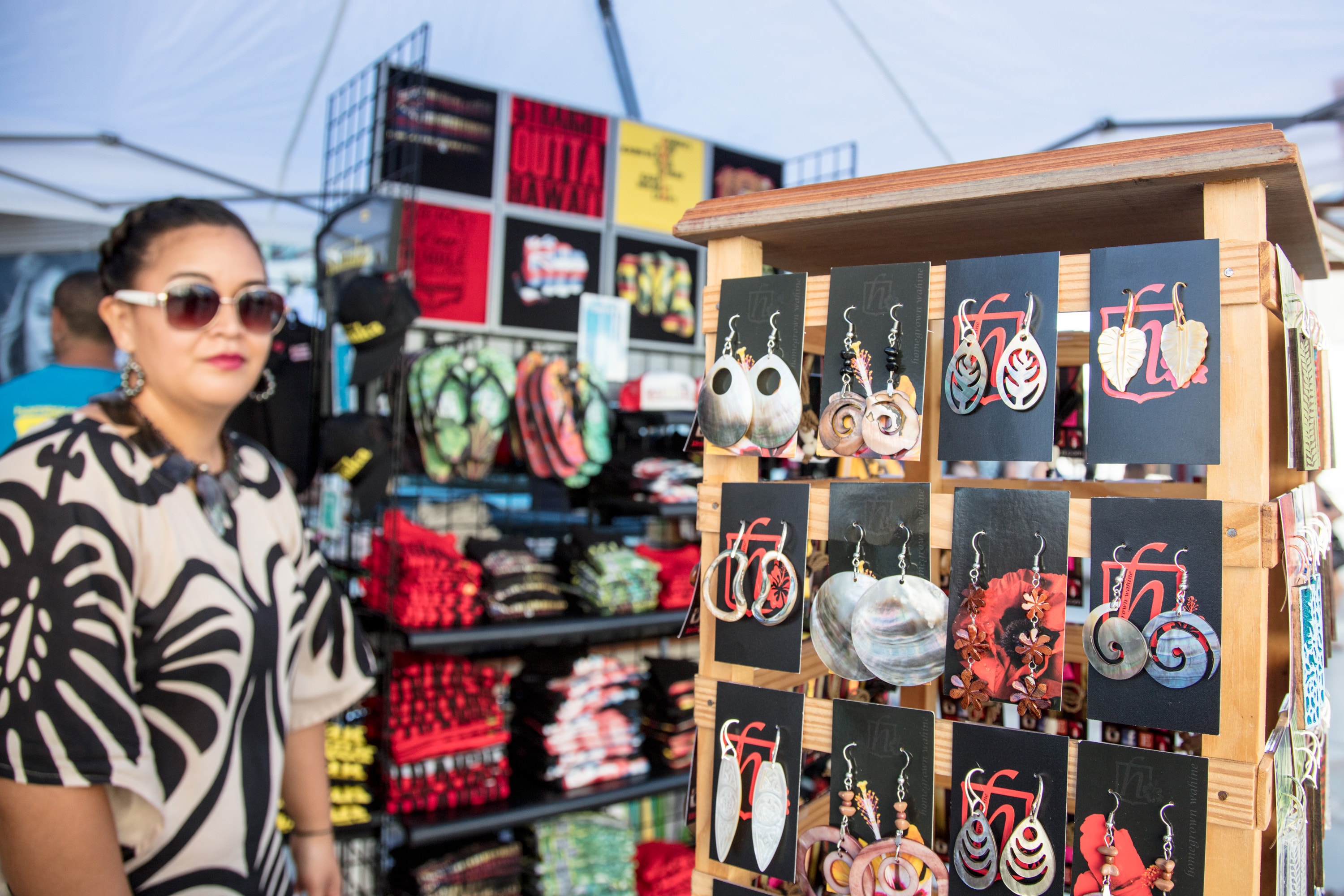 Woman shopping handmade earrings at market stall
