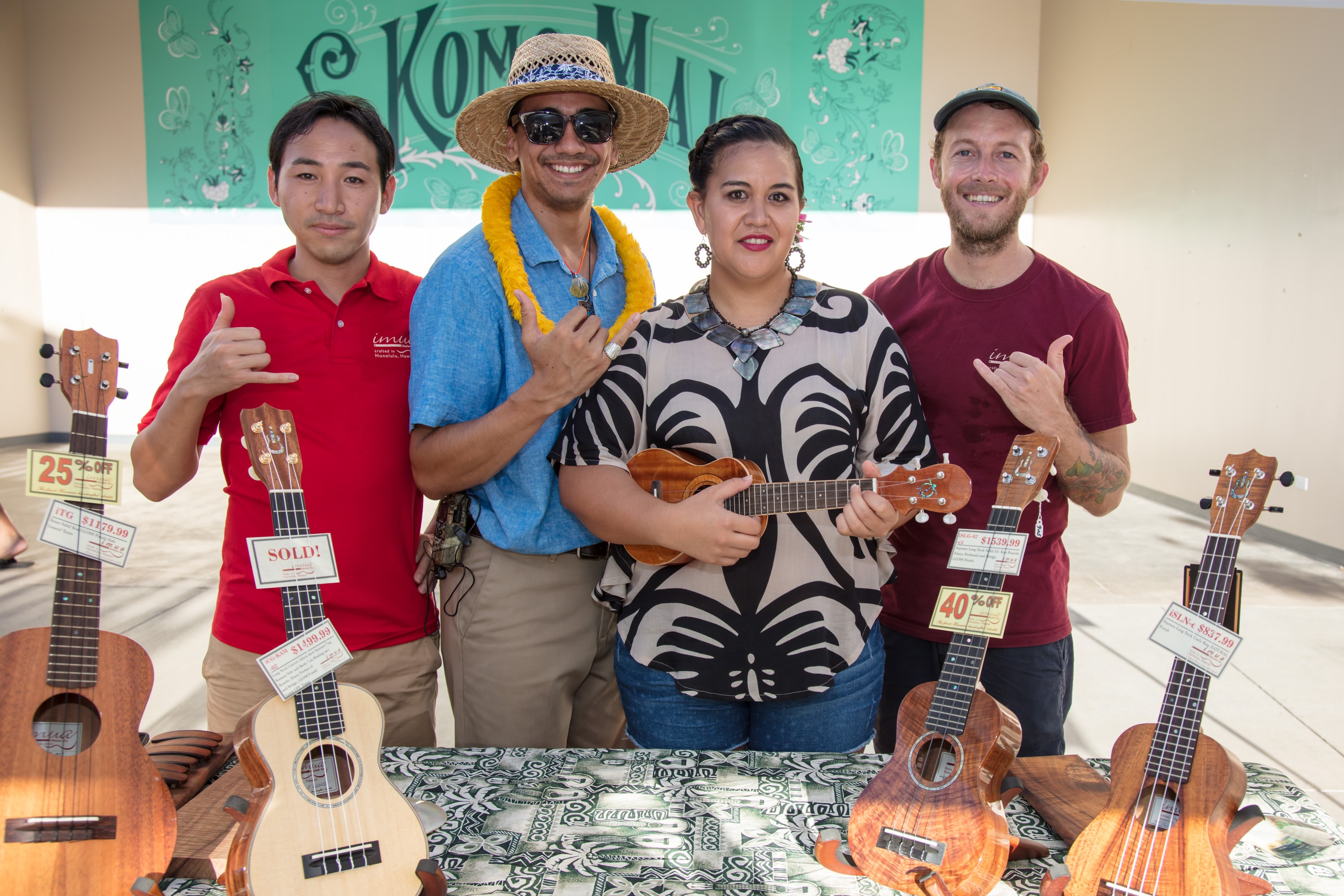Four musicians displaying ukuleles at event