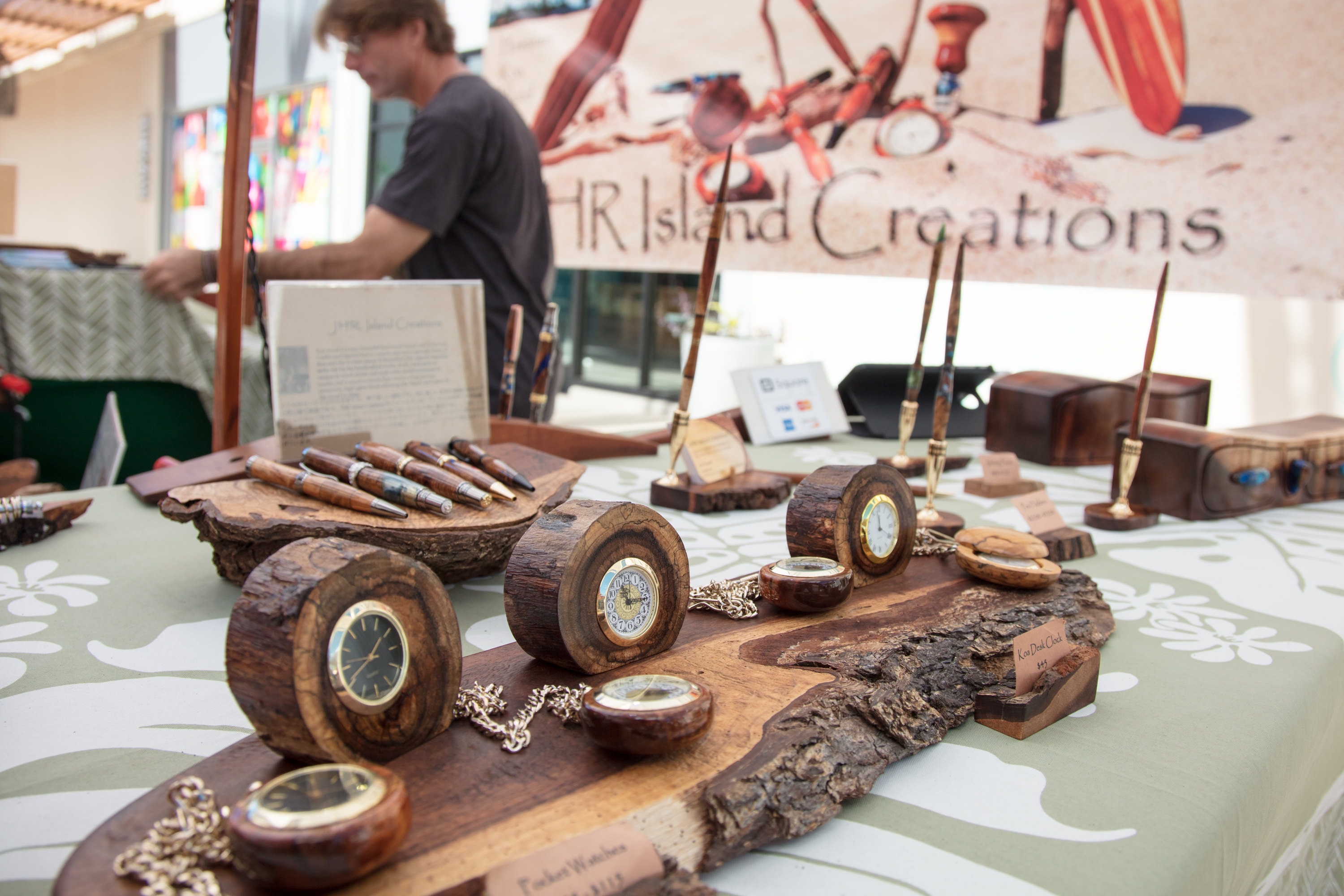 Handcrafted wooden clocks beach market display