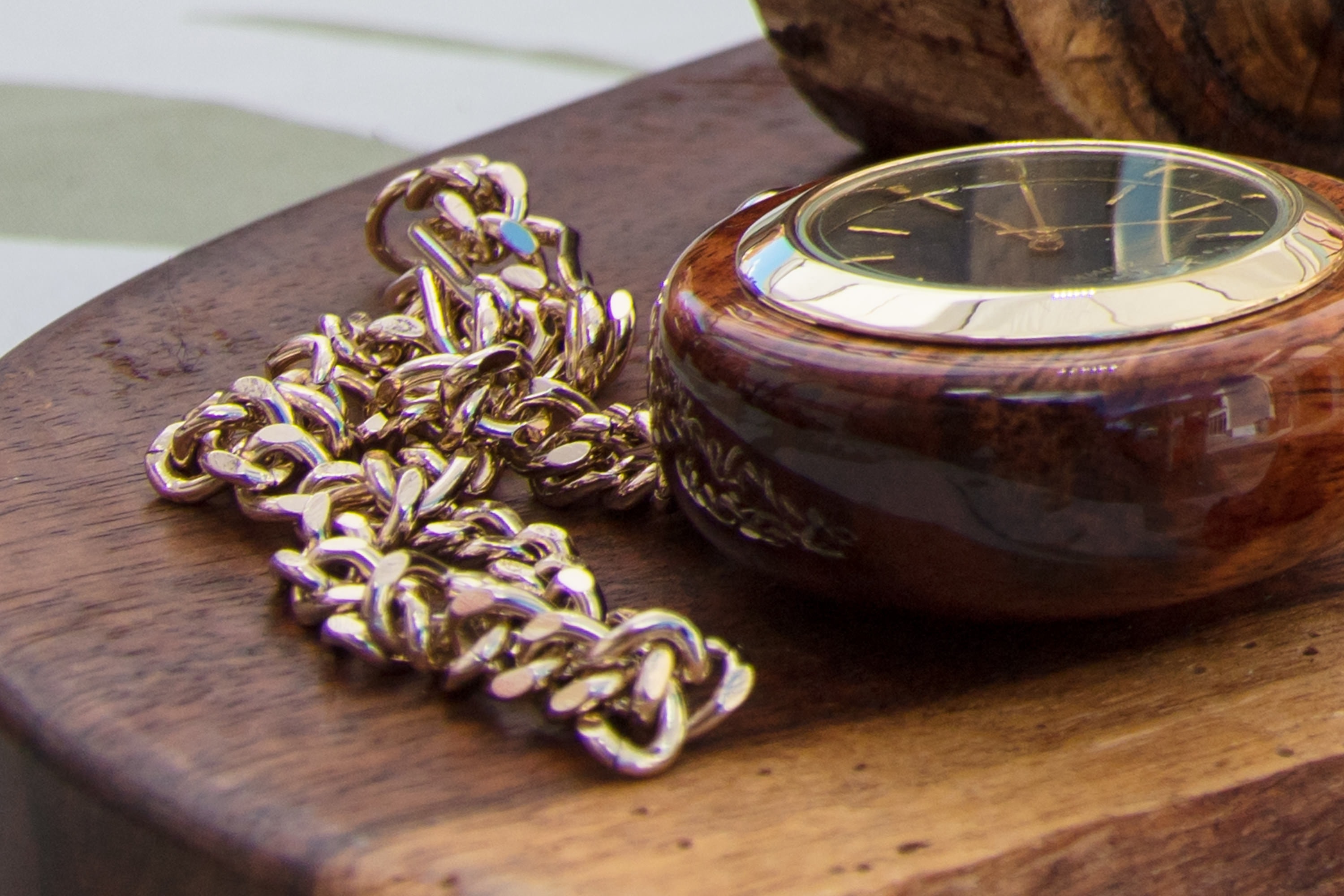 Ornate gold chain and wooden watch display