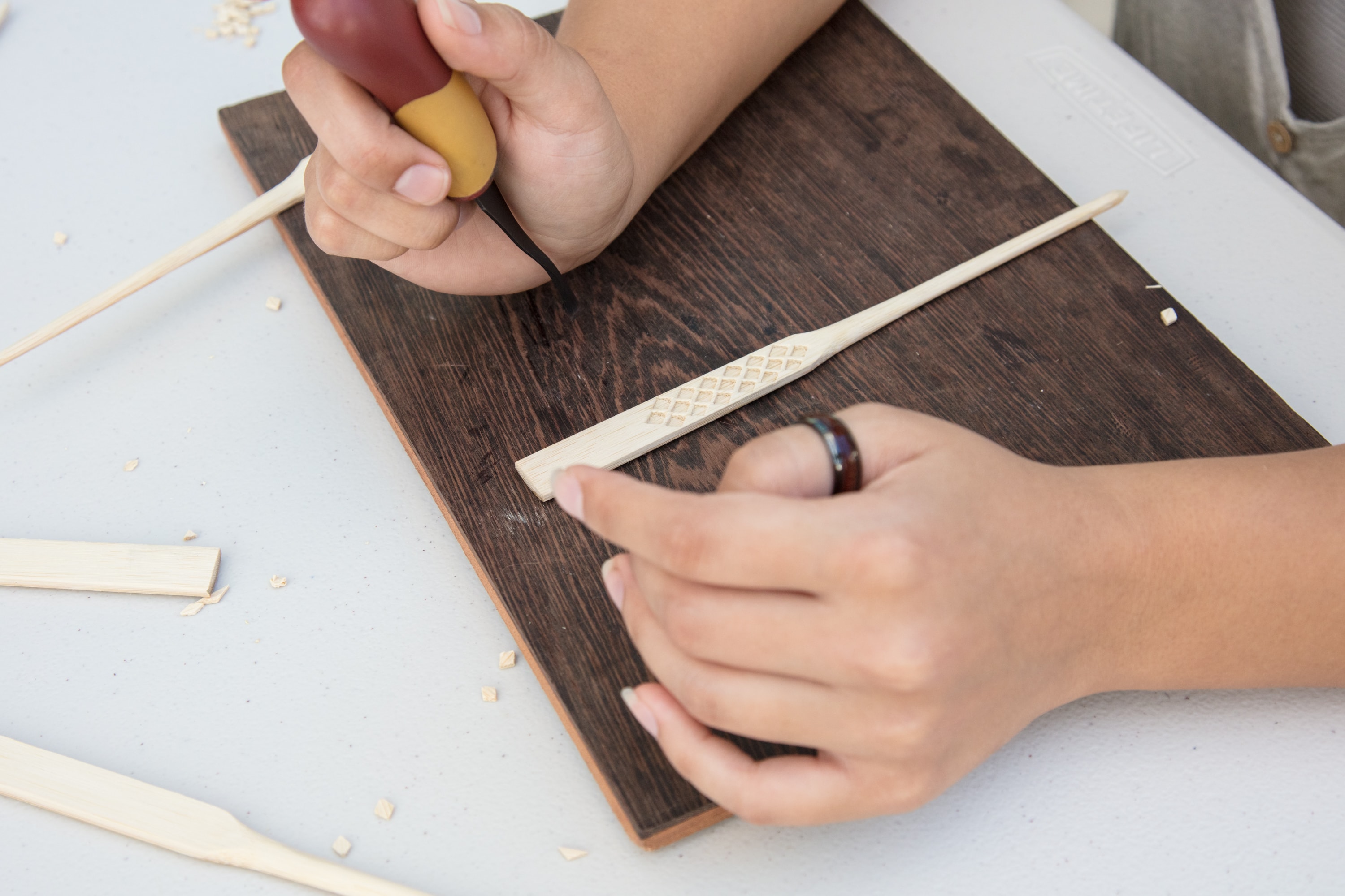 Child carving wood with tools