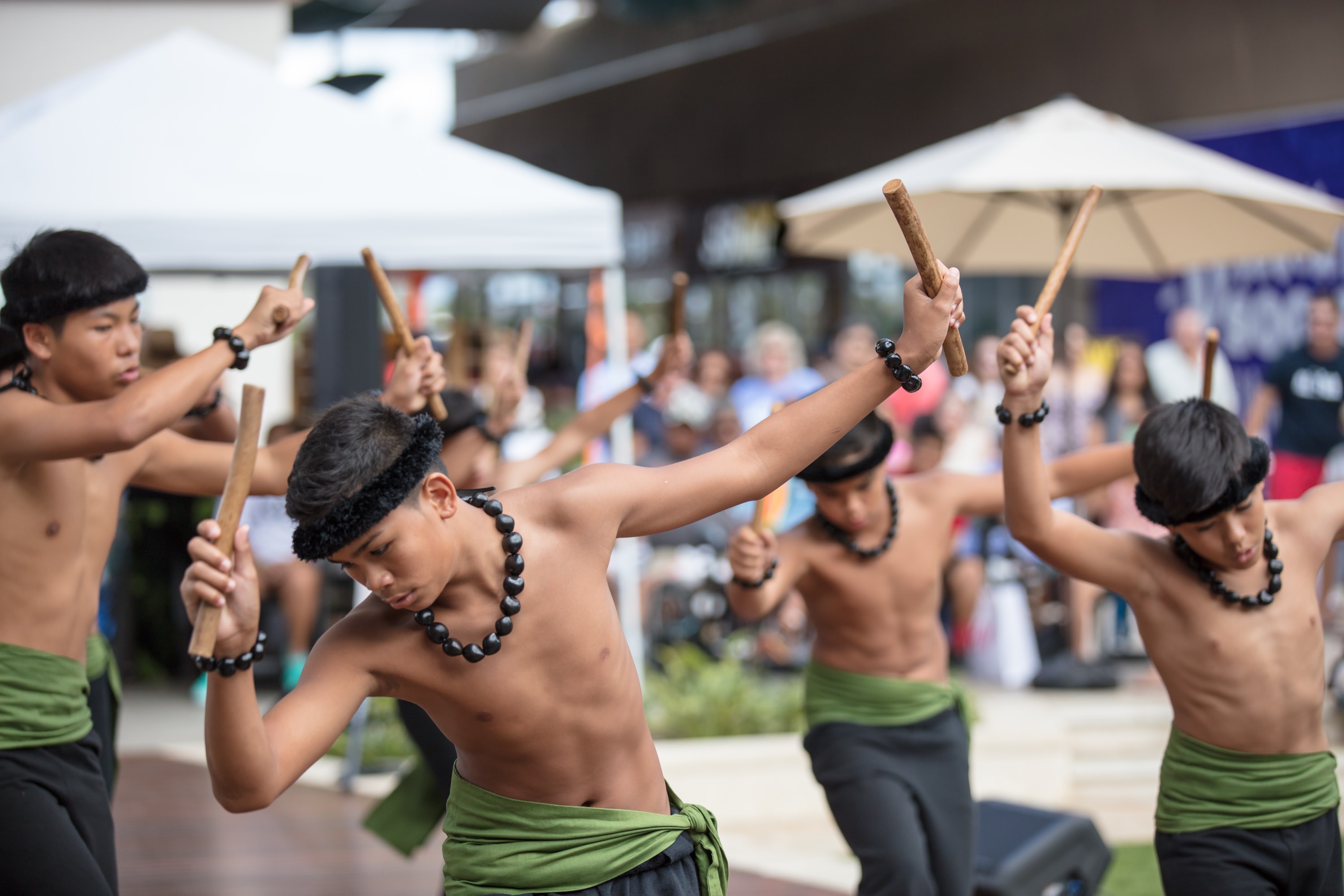 Indigenous performers dancing with wooden sticks