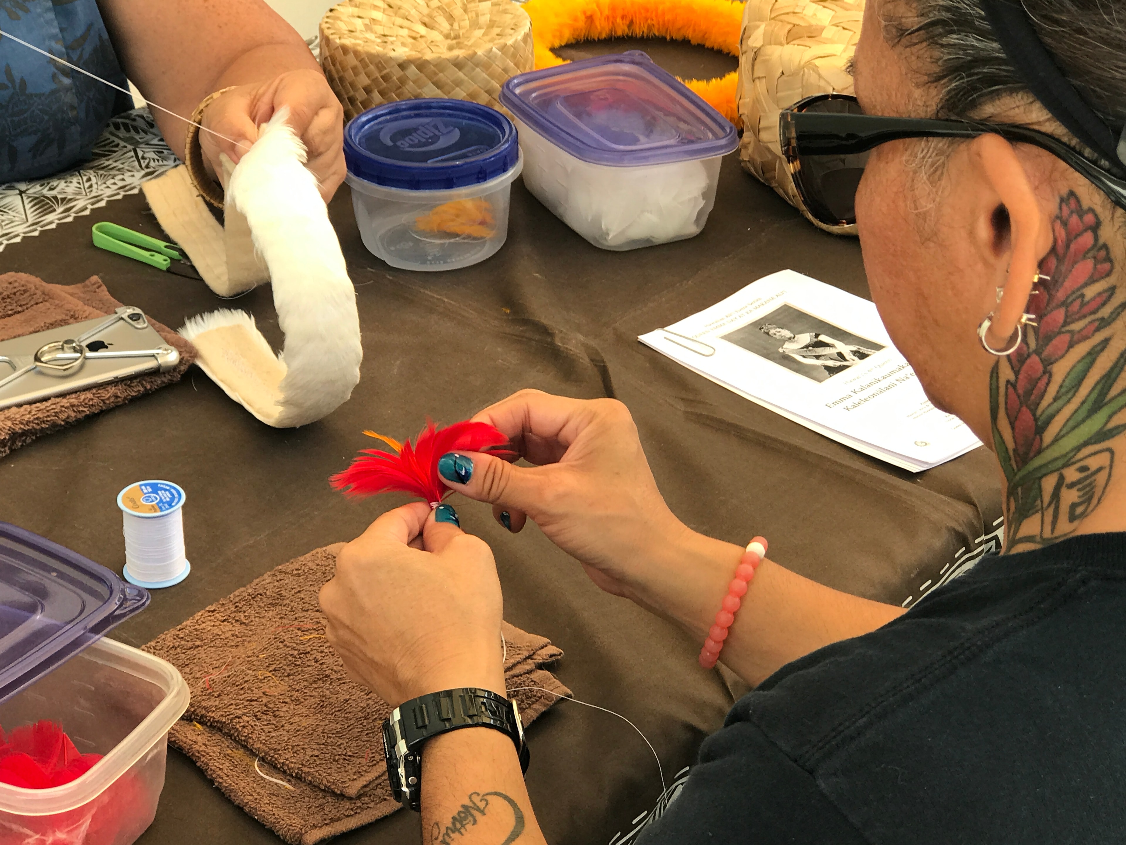 People crafting with feathers and supplies