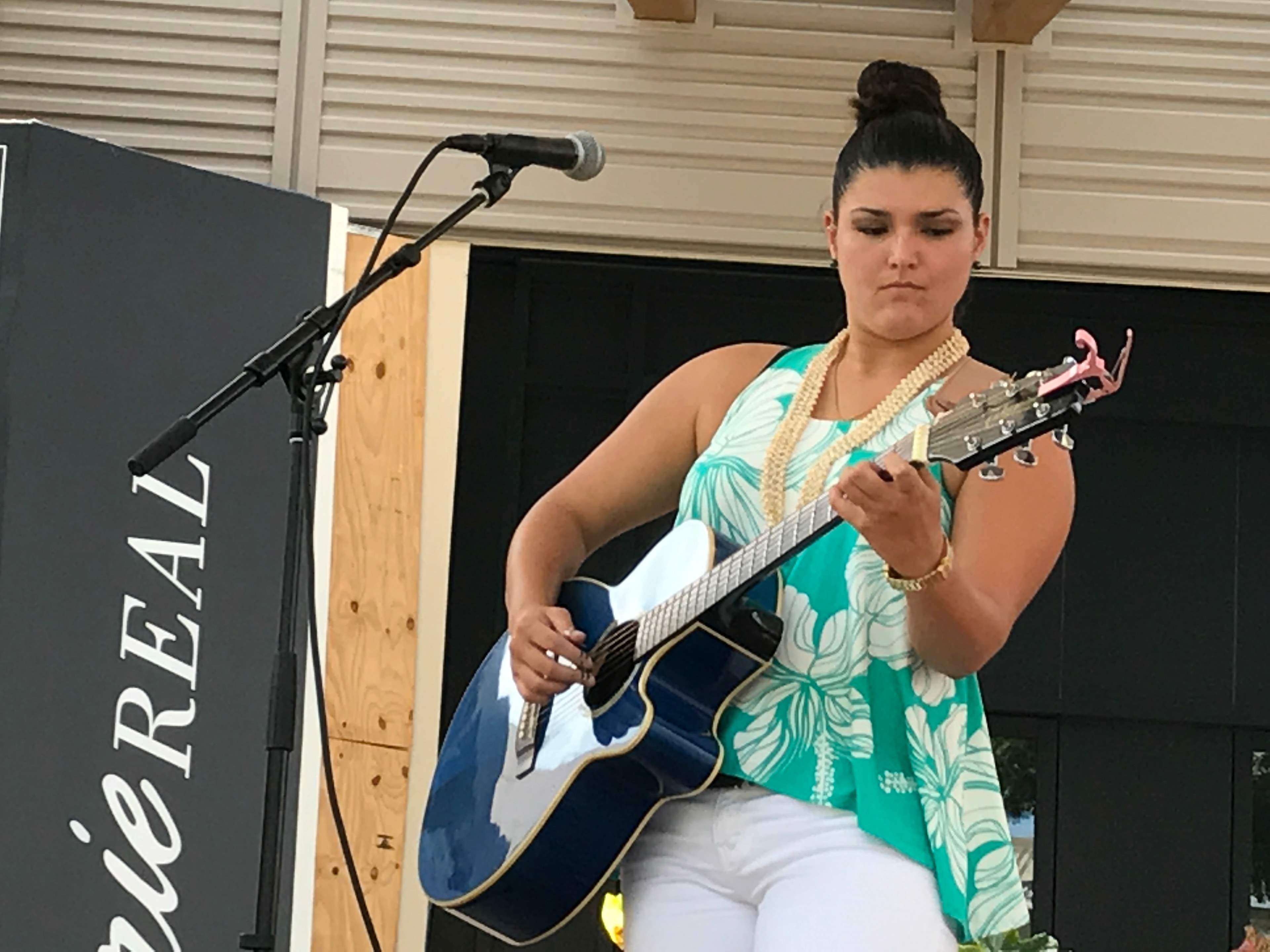 Woman performing acoustic guitar on stage